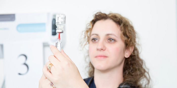 picture of a nurse preparing a needle for a flu shot